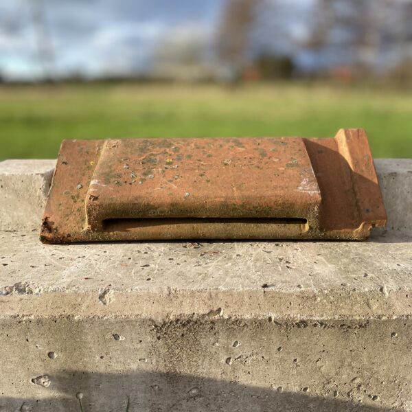 Reclaimed angle cap vent ridge tile.
